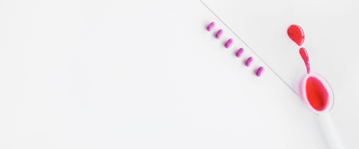 red-syrup-spoon-with-row-pills-white-background (2)